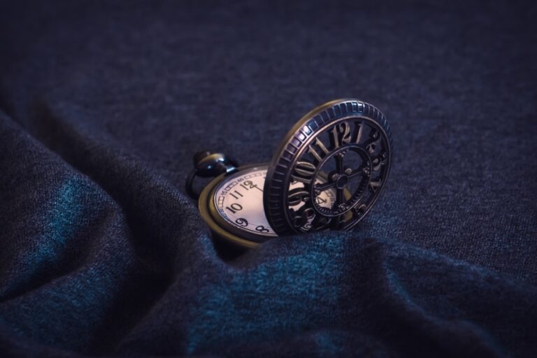 gold pocket watch on blue textile, time