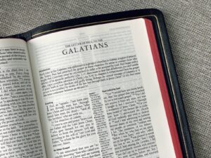 white book page on black and gray textile, Galatians