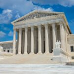 a large white building with columns with United States Supreme Court Building in the background