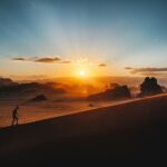 a person standing on top of a sandy hill