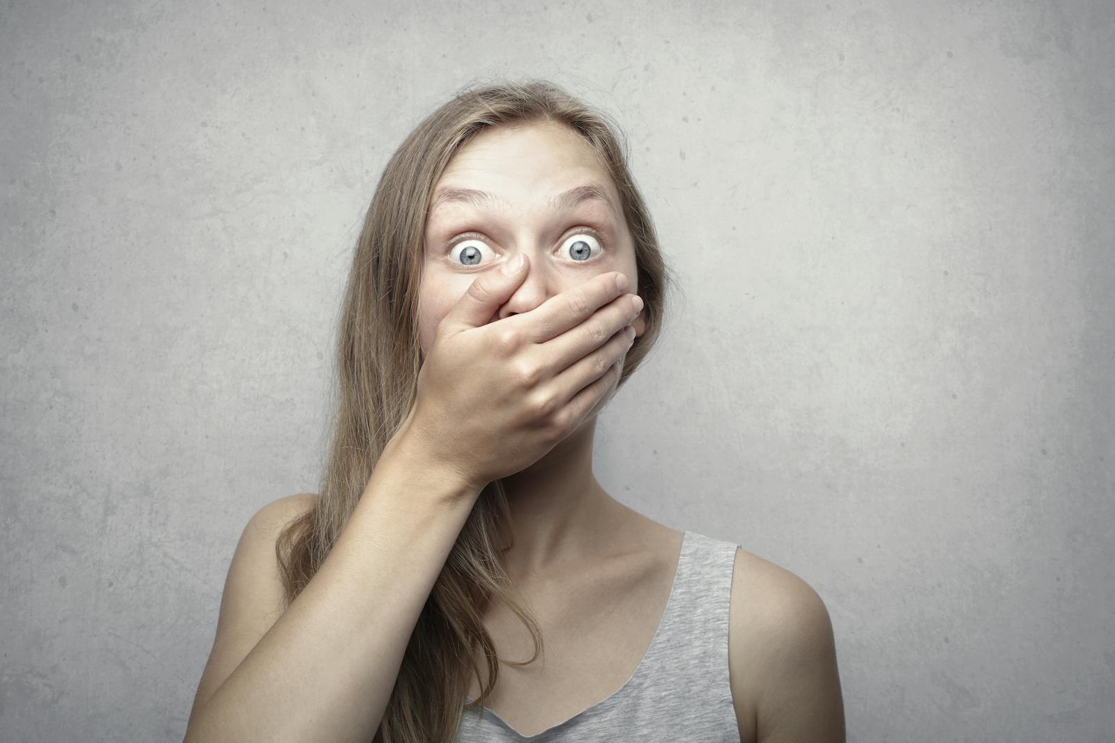 Woman in Gray Tank Top, shocked