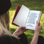 woman holding white and red book