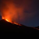 power, black mountain with flowing lava at nighttime