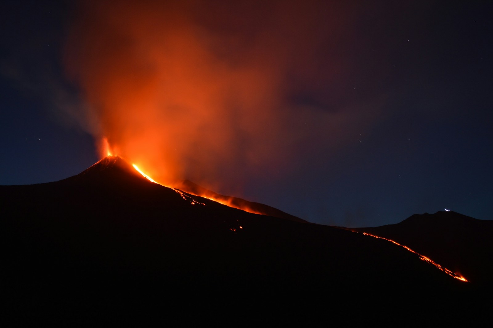 power, black mountain with flowing lava at nighttime