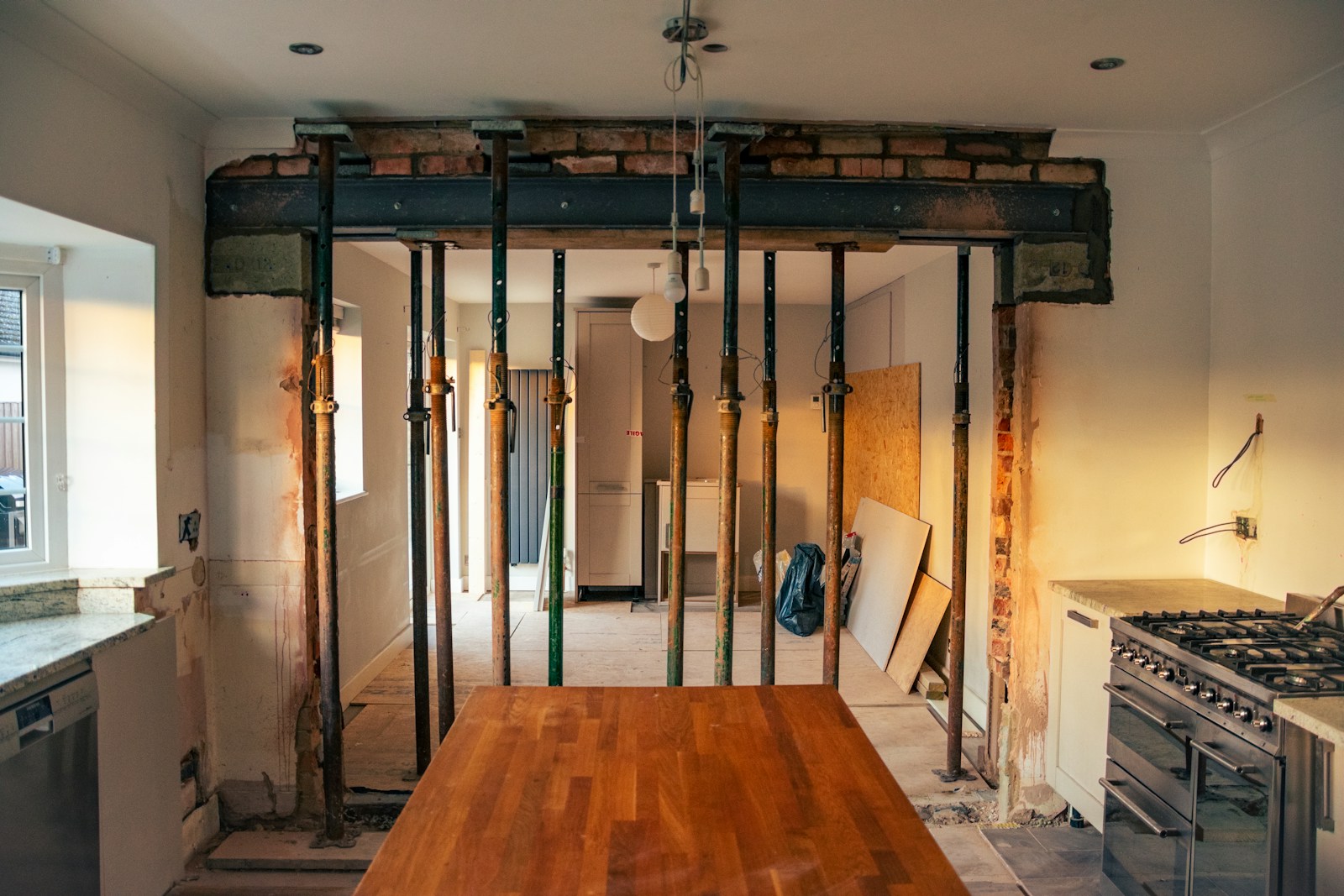 a kitchen with a wooden table in the middle of it