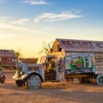 Colorful trucks with religious art at Salvation Mountain captured at sunset, California.