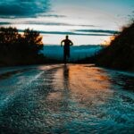 silhouette photo of a person running on road