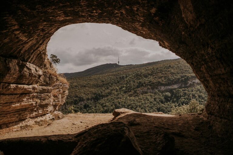 place of the overcomer, a view of a canyon through a hole in a rock