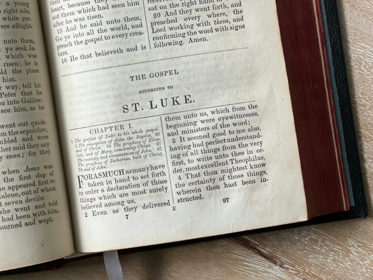 Luke, an open book sitting on top of a wooden table