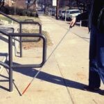 a man walking a dog on a leash down a sidewalk